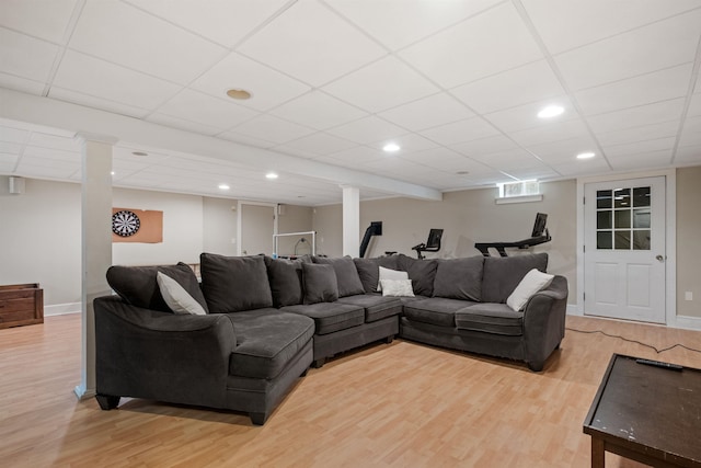 living area with light wood-style floors, baseboards, recessed lighting, and a drop ceiling