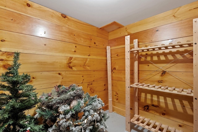 bedroom featuring wood walls and concrete flooring