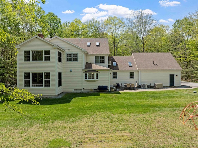 rear view of property with a patio area, a yard, and view of wooded area