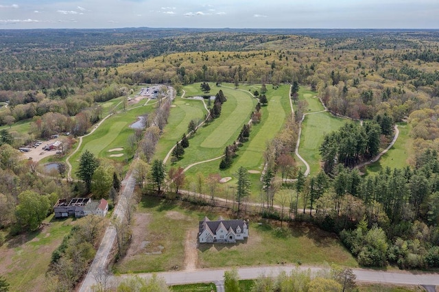 aerial view of property and surrounding area with a forest and a golf club