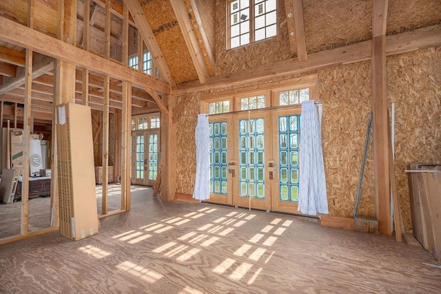 miscellaneous room with french doors, plenty of natural light, and high vaulted ceiling