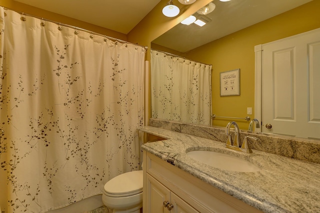 bathroom with toilet, vanity, and curtained shower