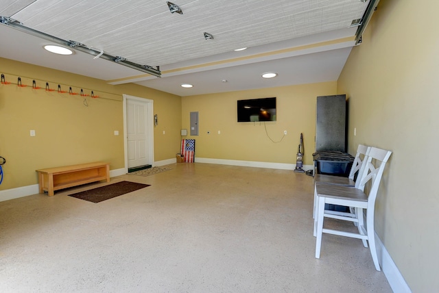 garage featuring baseboards, recessed lighting, and electric panel