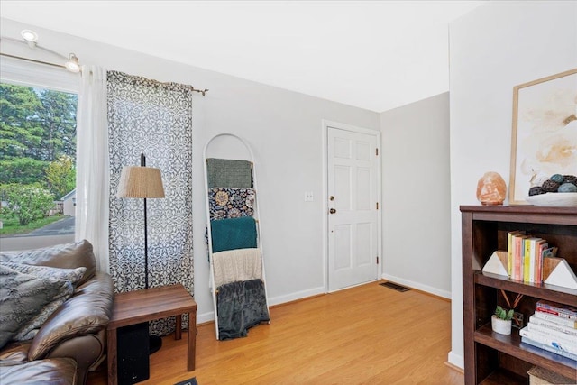foyer with light wood-style floors and baseboards