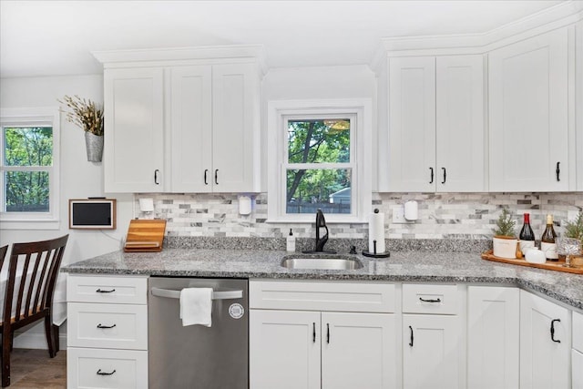 kitchen with dishwasher, a sink, plenty of natural light, and decorative backsplash