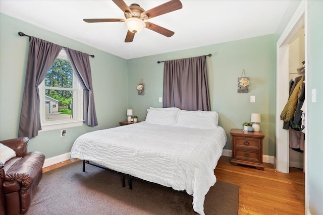 bedroom with wood finished floors, baseboards, and ceiling fan