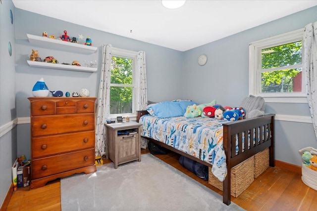 bedroom with light wood-style floors and baseboards