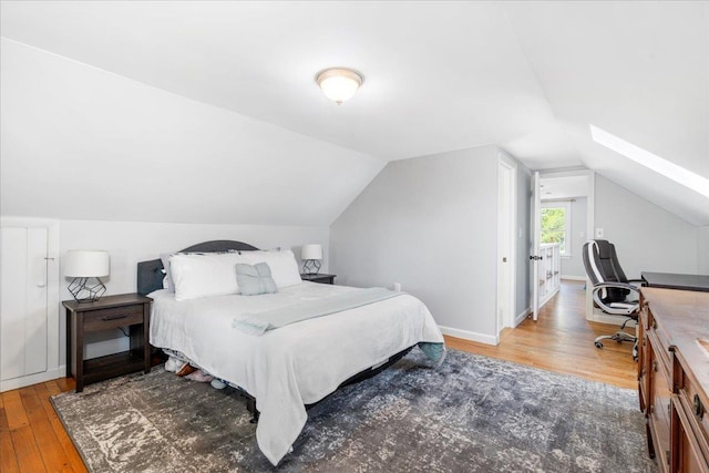 bedroom with hardwood / wood-style floors and lofted ceiling