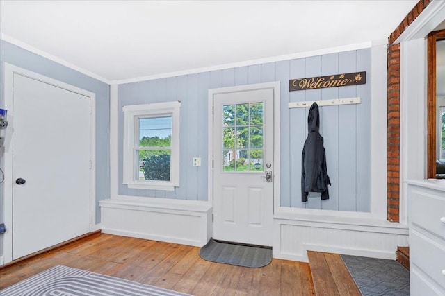 doorway with wood-type flooring and crown molding