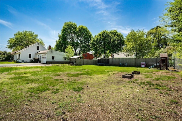 view of yard with a playground, a garage, and a trampoline