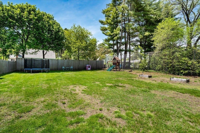 view of yard featuring a trampoline and a playground