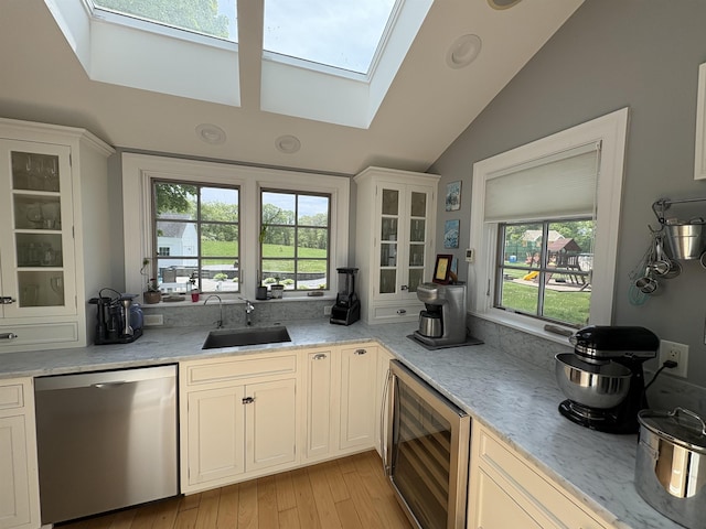 28-28A Ridge Rd, Hollis, NH 03049 - kitchen with stainless steel dishwasher, a sink, beverage cooler, a skylight, and lofted ceiling