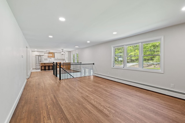41 Elk Dr, Bedford, NH 03110 - unfurnished living room with baseboard heating, light wood-style flooring, recessed lighting, and baseboards