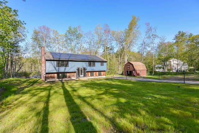 41 Elk Dr, Bedford, NH 03110 - back of property with a yard, a chimney, an outbuilding, a barn, and solar panels