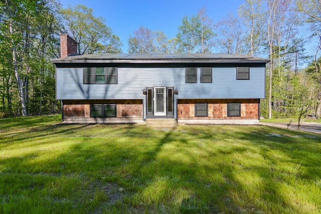41 Elk Dr, Bedford, NH 03110 - back of property featuring a chimney, solar panels, entry steps, and a yard