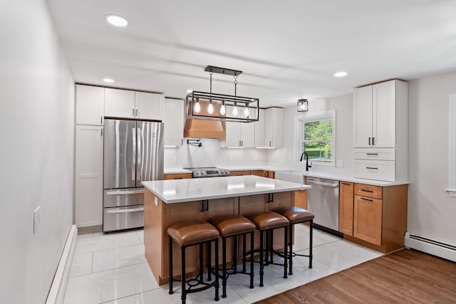 41 Elk Dr, Bedford, NH 03110 - kitchen with stainless steel appliances, a sink, a kitchen breakfast bar, a kitchen island, and light countertops