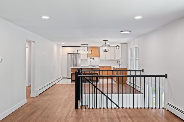 41 Elk Dr, Bedford, NH 03110 - kitchen featuring baseboard heating, light countertops, light wood-style floors, white cabinetry, and recessed lighting