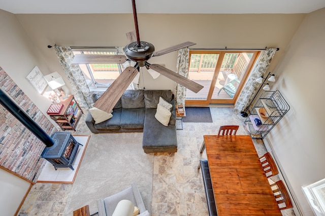 living area with a wood stove and ceiling fan
