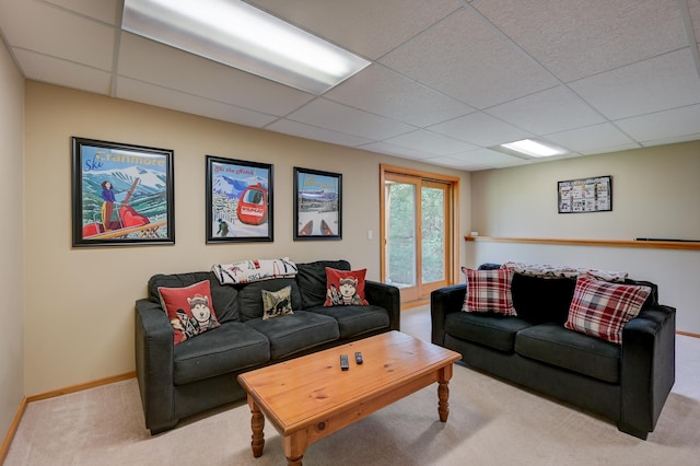 living area with carpet, a drop ceiling, and baseboards