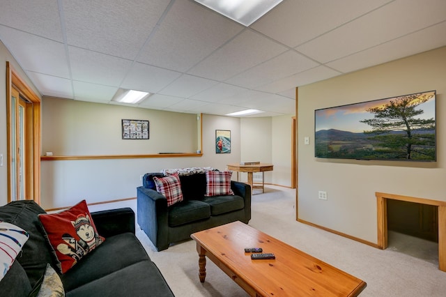 carpeted living room featuring a paneled ceiling and baseboards