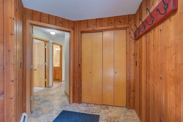 hall featuring wood walls and stone finish flooring