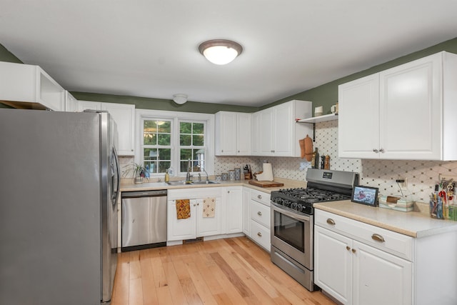 268 Lesmerises Rd, Loudon, NH 03307 - kitchen with appliances with stainless steel finishes, a sink, light wood-style flooring, backsplash, and white cabinets