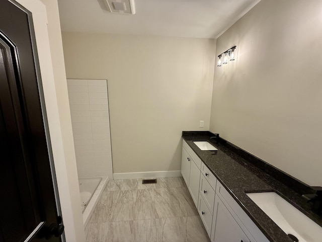 full bathroom featuring marble look tile flooring, double vanity, baseboards, and a shower