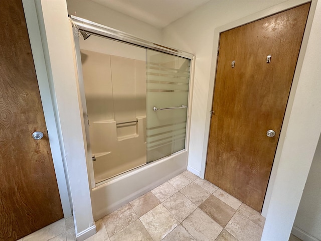 full bathroom with shower / bath combination with glass door and stone finish floors