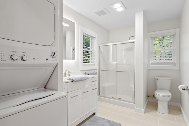 full bath featuring stacked washer and clothes dryer, a stall shower, and plenty of natural light