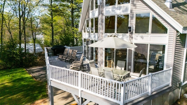 rear view of house with a wooden deck and outdoor dining space