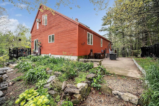 rear view of house featuring a deck, a patio, and fence