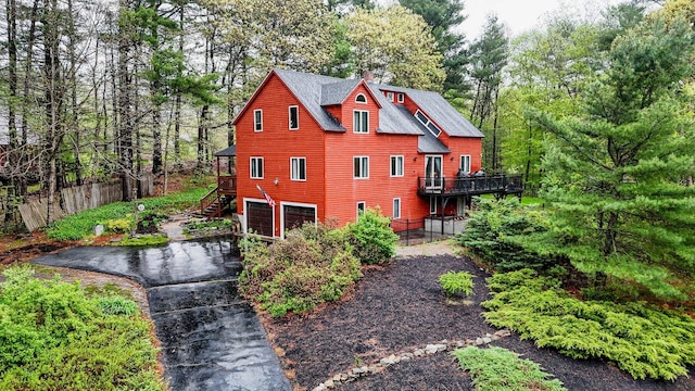 back of house featuring stairs, fence, an attached garage, asphalt driveway, and a deck