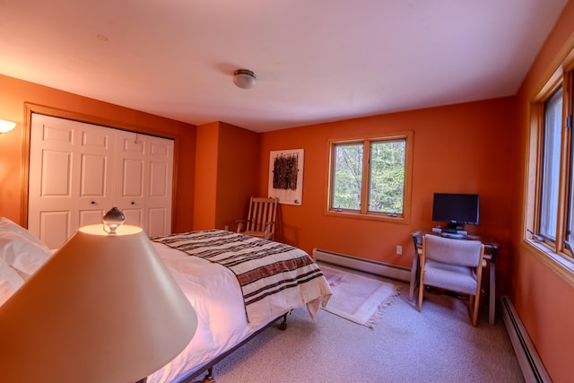 carpeted bedroom featuring a baseboard radiator, a closet, and baseboards