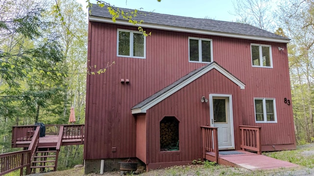 view of home's exterior featuring a deck, a shingled roof, and stairs