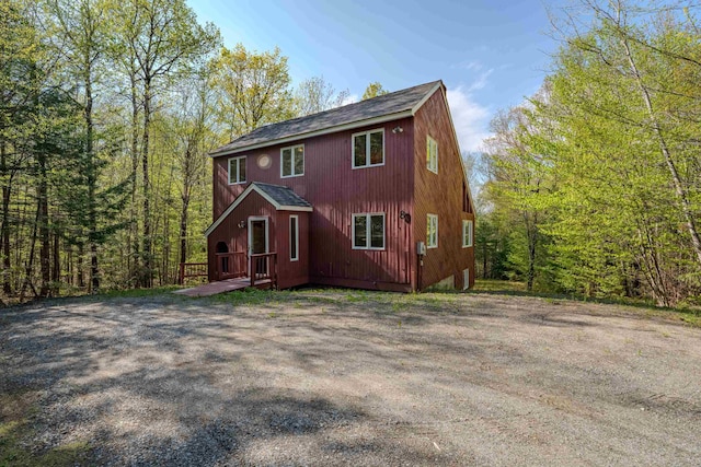 view of front of property with roof with shingles and a wooden deck