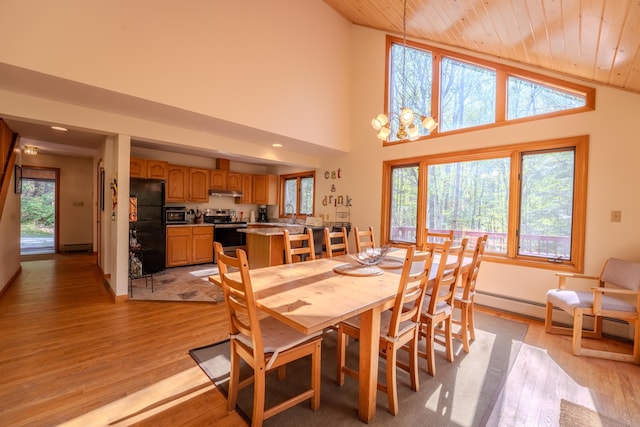 dining room featuring wood ceiling, plenty of natural light, light wood-style flooring, a baseboard radiator, and high vaulted ceiling
