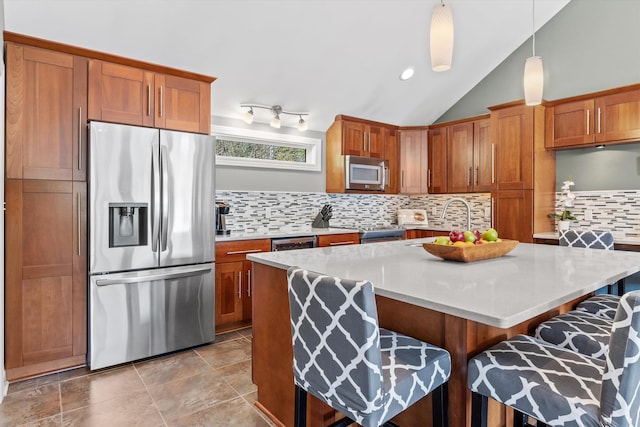 1385 Front St, Manchester, NH 03102 - kitchen with stainless steel appliances, a breakfast bar area, brown cabinets, and vaulted ceiling