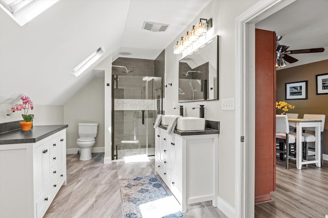 1385 Front St, Manchester, NH 03102 - bathroom featuring a shower stall, vanity, lofted ceiling, ceiling fan, and toilet