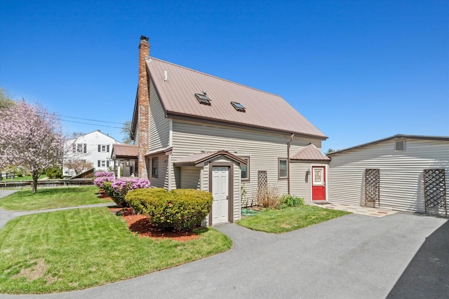 1385 Front St, Manchester, NH 03102 - view of front of house with metal roof, a chimney, and a front yard