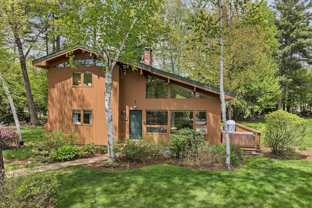 view of property exterior featuring a chimney and a lawn