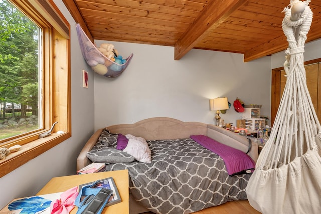 bedroom with wood ceiling, wood finished floors, and beamed ceiling