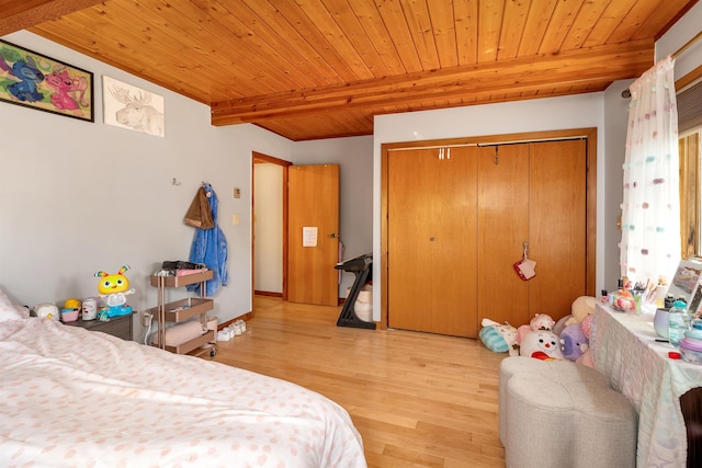 bedroom featuring wood ceiling, light wood-type flooring, a closet, and beam ceiling
