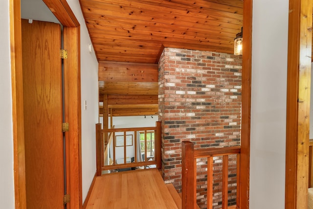 hallway featuring wooden ceiling, an upstairs landing, and wood finished floors
