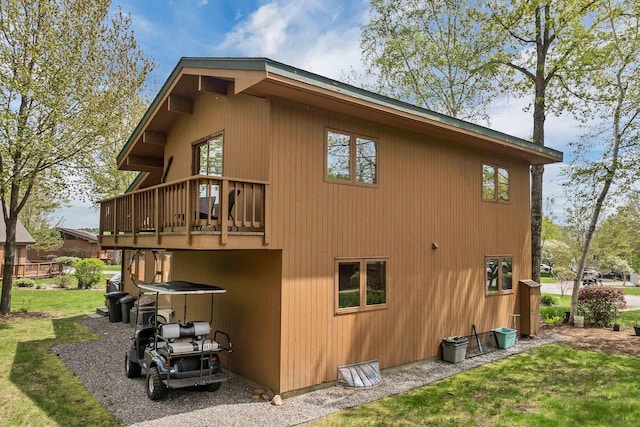 view of home's exterior with a lawn and a balcony