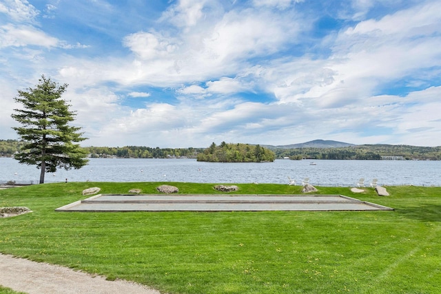 view of home's community with a water and mountain view and a lawn