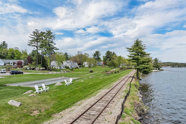 view of property's community with a water view and a yard