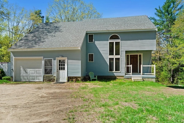rear view of property with driveway, roof with shingles, and a lawn