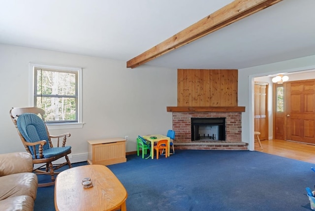carpeted living area with healthy amount of natural light, beam ceiling, a fireplace, and baseboards