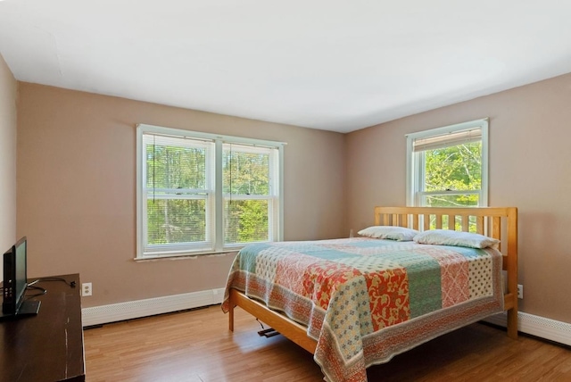 bedroom with wood finished floors and baseboards