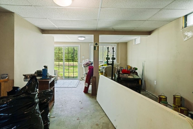 hallway with a drop ceiling and concrete floors